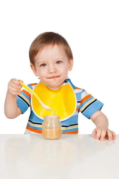 Junge isst mit einem Löffelpüree — Stockfoto