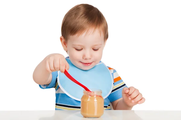 Boy eats with a spoon puree — Stock Photo, Image