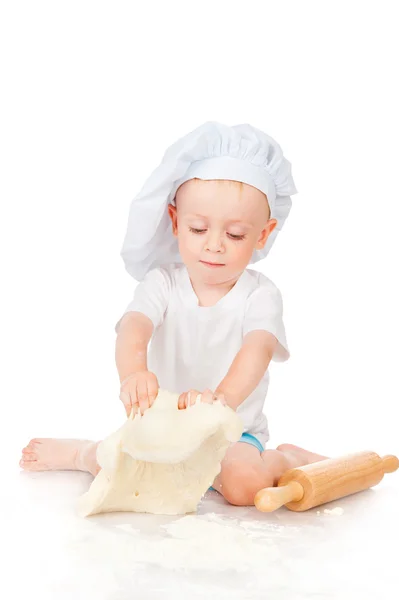 De kleine jongen rollen het deeg — Stockfoto