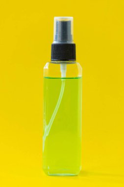 Square perfume bottle isolated on yellow background.