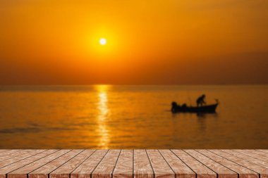 Empty wooden table on beautiful blurred sea sunset