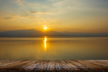 Empty wooden table on beautiful lake sunse
