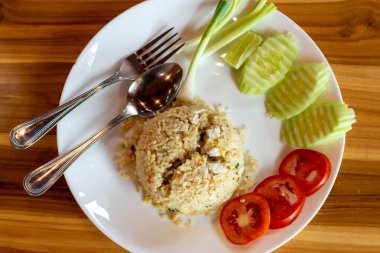 Crab meat fried rice and vegetable on a wooden table.
