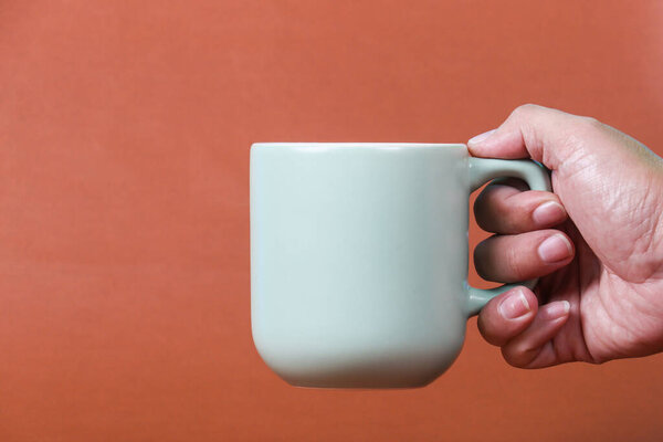 hand holding coffee cup with copy space for design wood grain vintage background