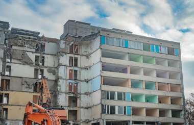 Bir kazıcıyla binayı sökmek. Eski bir binanın yıkımı..