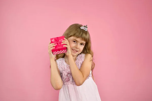 Menina alegremente posando em um fundo rosa. — Fotografia de Stock