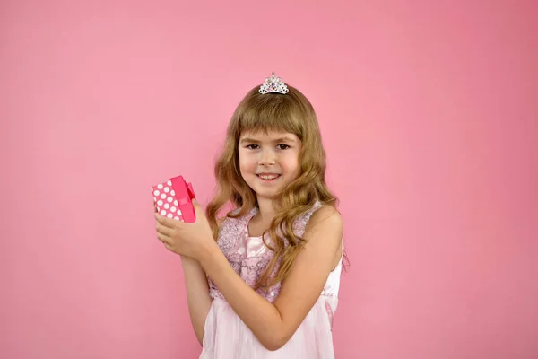 Menina alegremente posando em um fundo rosa. — Fotografia de Stock