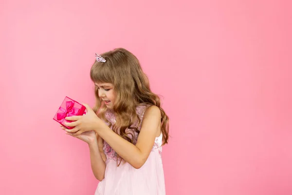 Menina alegremente posando em um fundo rosa. — Fotografia de Stock
