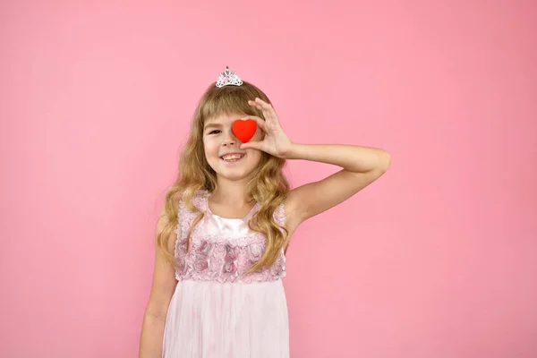 Menina alegremente posando em um fundo rosa. — Fotografia de Stock