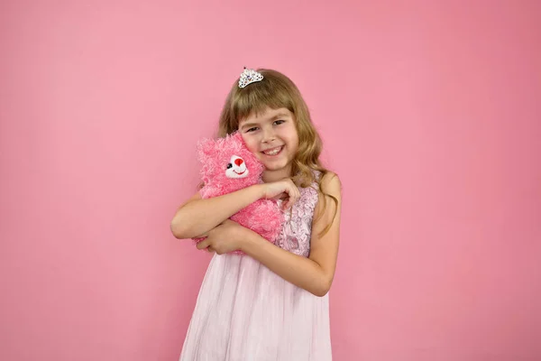 Menina alegremente posando em um fundo rosa. — Fotografia de Stock