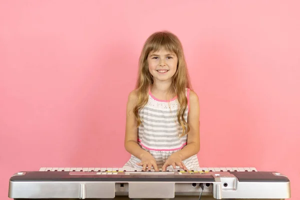 Uma Rapariga Vestido Toca Sintetizador Menina Vestido Fundo Rosa — Fotografia de Stock