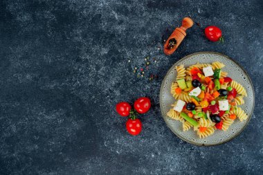 Sebzeli makarna, kuşkonmaz, bezelye, dolmalık biber, domates, sos, siyah arkaplanda mozzarella peyniri. Sebzeli İtalyan makarnası ve koyu bir arka planda baharat. Anlaşıldı..