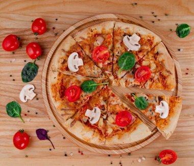 Tahtada domatesli ve mantarlı pizza. Mantarlı, domatesli, otlu ve biberli Mozzarella peynirli pizza..