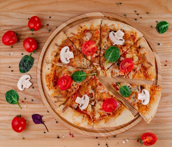 Tahtada domatesli ve mantarlı pizza. Mantarlı, domatesli, otlu ve biberli Mozzarella peynirli pizza..