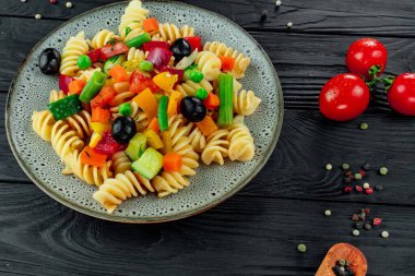 Sebzeli İtalyan makarnası ve koyu arkaplanda baharat..