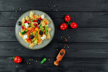 Sebzeli İtalyan makarnası ve koyu arkaplanda baharat..