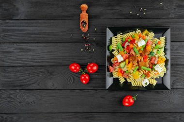 Sebzeli İtalyan makarnası ve koyu arkaplanda baharat..