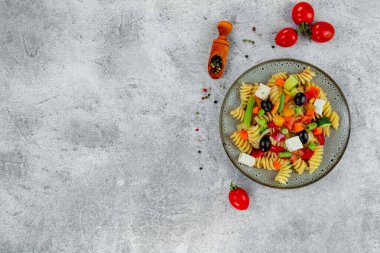 Sebzeli makarna, sos, arka planda hafif desenli mozzarella peyniri..