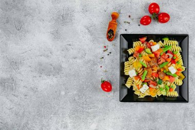 Sebzeli makarna, sos, arka planda hafif desenli mozzarella peyniri..