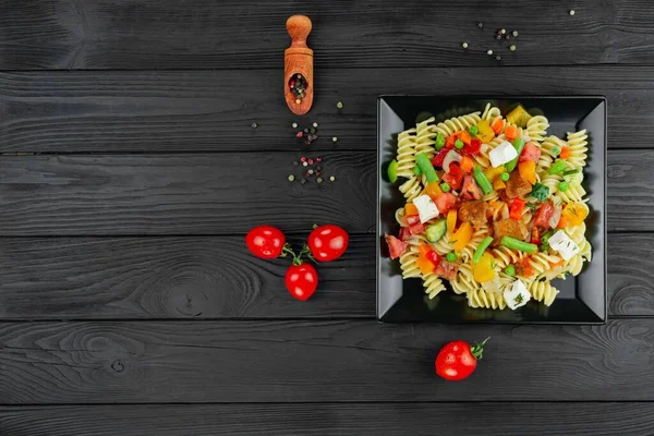 Sebzeli İtalyan makarnası ve koyu arkaplanda baharat..