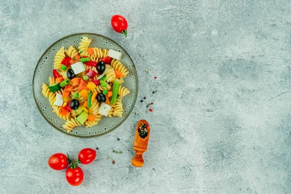 Sebzeli makarna, sos, arka planda hafif desenli mozzarella peyniri..