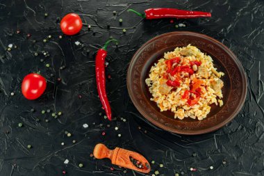 Geleneksel Asya yemeği - pirinç pilavı, sebze ve et siyah arka planda bir tabakta. Asya yemekleri. Yukarıdan görüntüle.