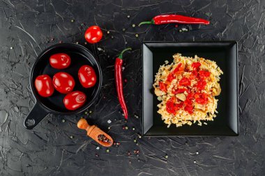 Geleneksel Asya yemeği - pirinç pilavı, sebze ve et siyah arka planda bir tabakta. Asya yemekleri. Yukarıdan görüntüle.