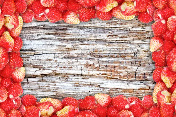 "Cornice di fragole selvatiche sullo sfondo texture di legno ." — Foto Stock