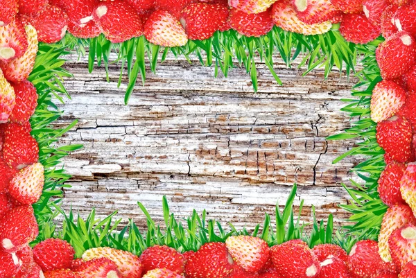 "Rahmen aus Erdbeeren und Gras und Holz Hintergrund." — Stockfoto