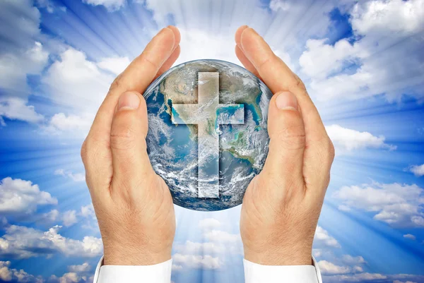 Hands holding the planet Earth with the Christian cross ."Elements of this image furnished by NASA". — Stock Photo, Image