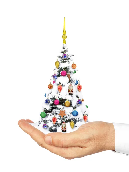 La mano sostiene un árbol de Navidad decorado en la nieve —  Fotos de Stock