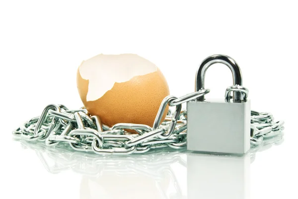 A casca de um ovo, coberto com um cadeado de corrente — Fotografia de Stock