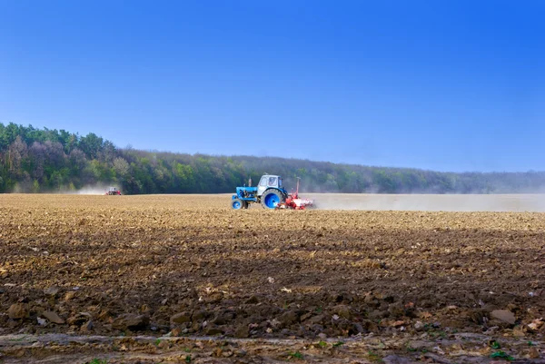 Trator para trabalhos agrícolas em um campo arado — Fotografia de Stock
