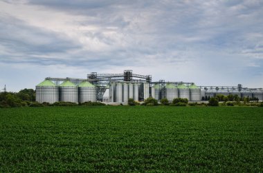 Industrial buildings and manufacturing equipment near an agricultural field. Elevator