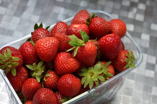 Red, ripe strawberries in a transparent plastic container