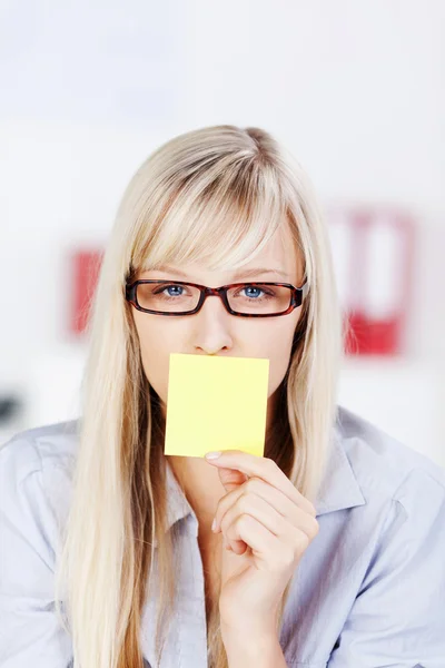 Mujer con tarjeta amarilla en la boca — Foto de Stock