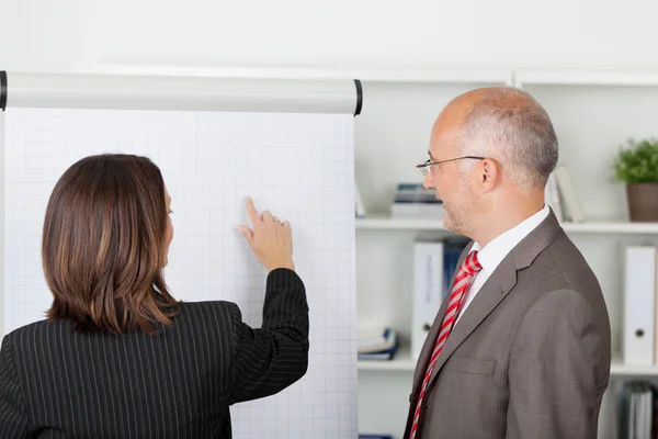 Empresário e empresária discutindo sobre Flipchart — Fotografia de Stock