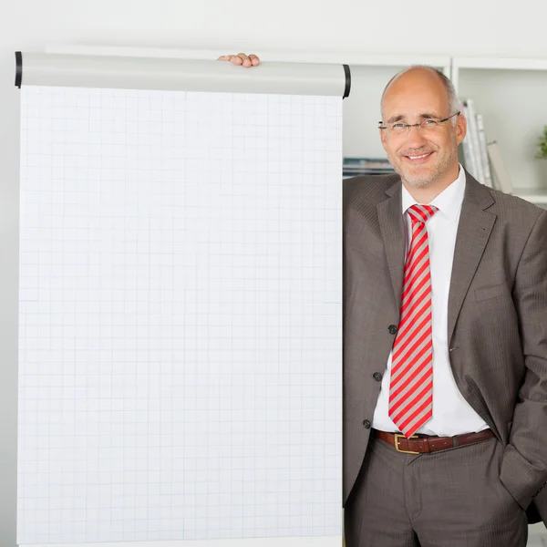 Homme d'affaires debout près tableau à feuilles mobiles dans le bureau — Photo