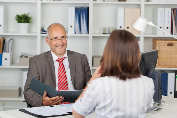 Affärsman håller cv kvinnlig kandidat vid skrivbord — Stockfoto