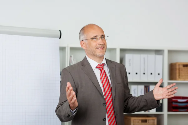 Affärsman gestikulerande samtidigt ge presentation i office — Stockfoto