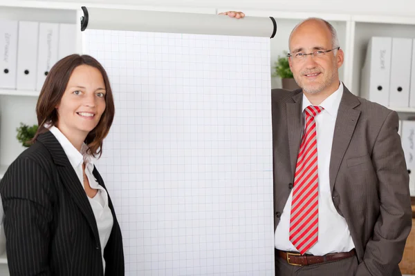 Two colleagues standing next to white flipchart — Stock Photo, Image