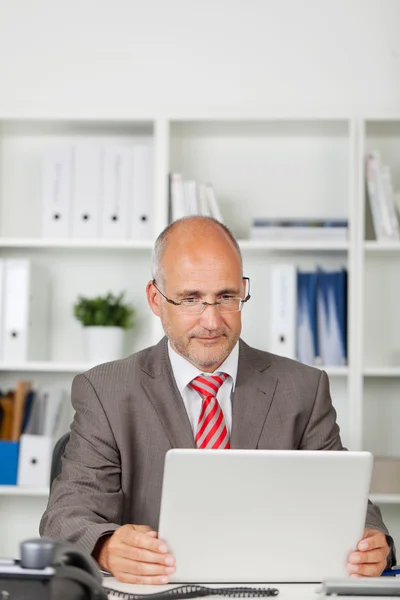 Biznesmen skoncentrowany na swoim laptopie — Zdjęcie stockowe