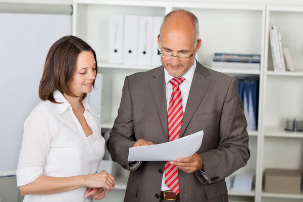 Businesspeople Reading Document In Office — Stock Photo, Image