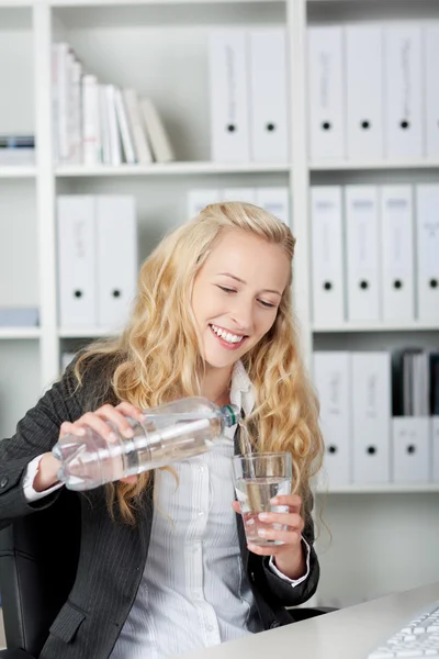 Happy Young Businesswoman Pouring Water In Glass — Stock Photo, Image
