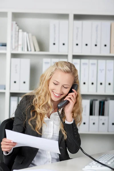 Empresaria leyendo un fax y hablando por teléfono — Foto de Stock