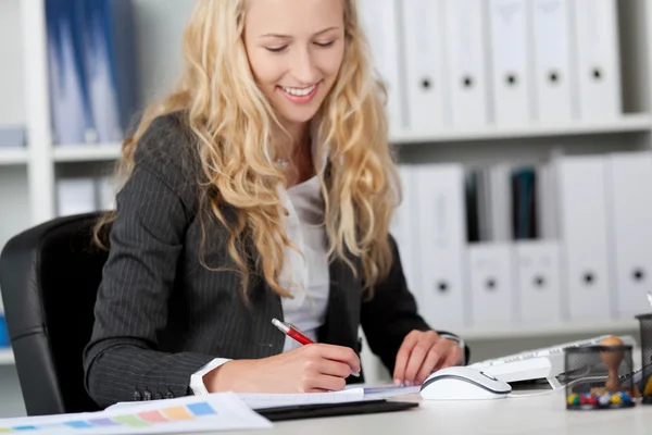 Zakenvrouw schrijven op papier op Bureau — Stockfoto