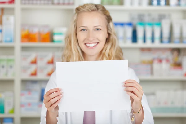 Vrouwelijke apotheker bedrijf blanco papier — Stockfoto