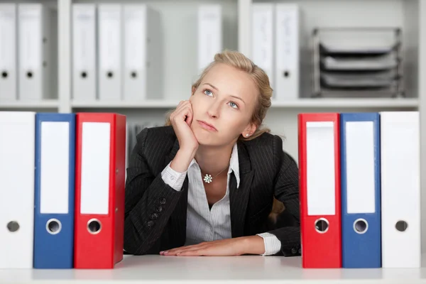 Gelangweilte junge Geschäftsfrau mit Ordnern — Stockfoto