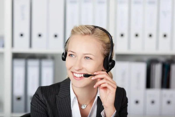 Ejecutiva de servicio al cliente femenina usando auriculares — Foto de Stock