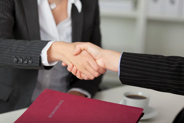 Businesswoman Shaking Hands At Desk — Stock Photo, Image